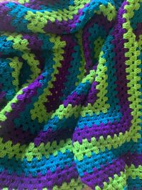 This is a hand crocheted giant granny square blanket in the colors of blue, green and purple. This would be an ideal gift for someone who loves bold colors for decorating, like cool tones, or just to give to somebody who loves cozy blankets. [COLORS IN BLANKET] - Blue - Green - Purple [SIZE]  Length: About 57 inches (~4.75 Feet) Width: About 57 inches (~4.75 Feet) [NOTE] -Item is brand new  -Item was hand crocheted  -Selling item as pictured and only what is pictured  -It was difficult to photograph truest tone of colors. The best picture to judge the colors is in the photograph with the tape measure. -< NO RETURNS >-