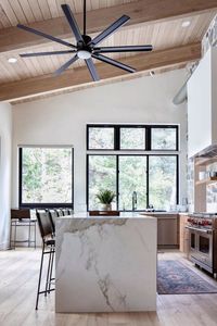 This kitchen by @lindsay_hill_interiors is an excellent example of modern organic design. Rustic elements like fieldstone walls are paired with a sleek contemporary stone island and our beautiful and expansive Vast ceiling fan. Learn more: 📷: @lindsay_hill_interiors on IG