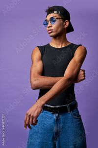 Stock Image: Hispanic transgender young man in casual dress close up portrait on purple background. Latino model