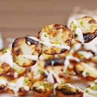 Now we want to grill all our potatoes! Add a drizzle of ranch dressing and you'll never look back. Get the recipe at Delish.com. #delish #easy #recipe #grilled #grilling #grilledpotatoes #ranchpotatoes #summer