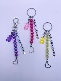 Personalised beautiful coloured and silver beaded keychain | keyring | bag charm. With white letter charms - you choose a name a friend or family name or a word that has a special meaning to someone. Addition of silver heart and stars and gummie bears to co-ordinate ALSO YOU WILL NEED TO MESSAGE US TO LET US KNOW IF YOU REQUIRE A RING OR CLIP ONCE ORDERED X 11 CM LONG IN TOTAL 2.5 cm silver ring 3 cm silver clasp 2 cm silver heart charm at bottom 1 cm star 6mm acrylic beads with 4mm stainless si