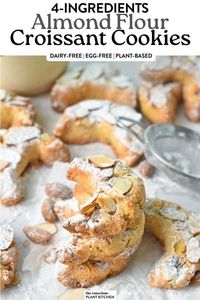 a stack of almond shaped croissant cookies with toasted sliced almonds on top and a dust of powdered sugar