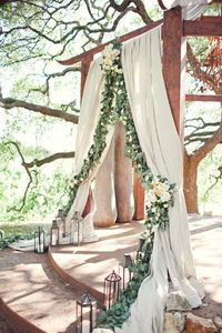 Elegant meets rustic in this magical altar, where eucalyptus leaves, flowing curtains, and a bare wooden gazebo dance together in an eye-catching symphony.Related:�50 Gorgeous Wedding Ceremony Structures