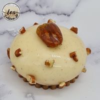 Entremet pécan composé d’un biscuit pécan, d’un croustillant pécan, d’un insert crémeux praliné pécan, d’une mousse vanille et d’un glaçage miroir.