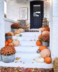 Fall front porch decor using pumpkins and mums.