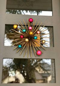 Add glass ornaments to a starburst for a mid mod Christmas door decoration.