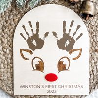 Our DIY reindeer handprint sign is the perfect keepsake for your baby's first Christmas!  DETAILS:  *Measures 8.5" wide x 10" tall   *Laser cut and engraved *Made out of 1/8" thick wood   *Paint for handprint is not included  These signs are intended for indoor use only. The back of the sign is raw, unfinished wood.   Check out the rest of our Christmas decor! https://etsy.me/3vFnqz2 ++ KEEP IN MIND ++   Each piece of wood is one of a kind, making no two signs alike. Due to the grain of the wood