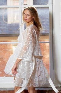 Embroidered floral vines bring dreamy romance to a sheer tulle wrap robe secured by a smooth satin sash. 35" length (size medium) Three-quarter sleeves Removable sash Sheer 100% polyester Hand wash, dry flat Imported