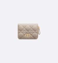 The Dior Caro Scarlet wallet features an elegant CD signature on its flap and hallmark Cannage topstitching. Crafted in sand-colored supple calfskin, the lightweight and practical daily essential can be combined with other pieces from the Dior Caro line and may be slipped into any bag..