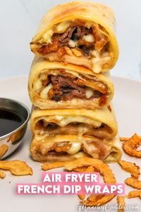 Air fryer French dip wraps cut in half and stacked open-faced showing roast beef, melted provolone cheese, and crispy fried onions.