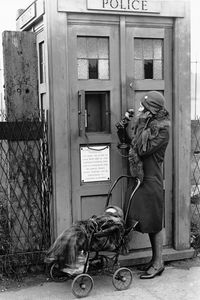 In 1929 the very first Police Boxes designed by Gilbert MacKenzie Trench, architect for the Metropolitan Police Service, were first installed on the streets of London. The first 10 prototype boxes were made from wood and had a simple stencilled Police sign on top, a glass door for the telephone and the white signage on the panel below.