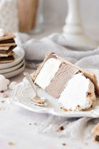 A homemade s'mores ice cream cake with no-churn ice cream, graham crackers, ganache, and whipped cream. Top it with marshmallow fluff and chocolate for a fun and delicious birthday cake that everyone will love.