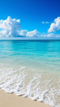 Serene tropical beach with crystal clear blue waters, soft white sands, and fluffy clouds overhead.