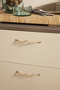 Curvature Handles. Curvature is a series of organically shaped accessories for the home that have been hand formed in pure, solid brass with a matte finish. The whimsical curves juxtapose the solidity of the material, and make a feminine, functional addition to any bedroom, bathroom, hallway or kitchen. The Curvature Handle will add a decorative, unique touch to any cupboard, cabinet or drawer