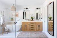 A large and spacious master bathroom with light wood, white tile, and a great tub. #homedecor #bathtub #freestandingtub #coastalstyle