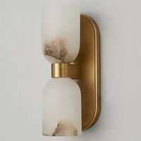 The elegant contours of this double sconce are adorned by two classic alabaster bowl shades, making it a timeless piece. Alabaster is a natural stone, so veining and tone variations are expected and celebrated as they add exclusivity to each light.