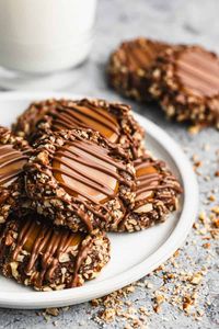 Turtle cookies are delicious chocolate cookies, rolled in pecans, filled with melted caramel and drizzled with melted chocolate. Our favorite Christmas cookie recipe!