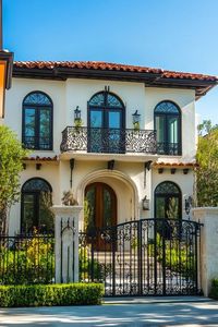 Modern mediterranean revival architecture home facade with wrought iron balconies. Check out all of these stunning exteriors of Mediterranean Revival architecture that bring a touch of sun-soaked elegance to the home.