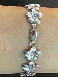 Elegant And Beautiful Hawaiian 14mm Plumeria Flower Lei Bracelet 7 1/4" in 14K Solid White Gold  Diamond Cut on the edges of each petal. 14 Karat Solid White Gold GUARANTEED, Authenticated with a 14K Stamp Made With the Highest Quality Craftsmanship Solid 14K White Gold Plumeria Flower Lei Link Bracelet  Length 7.25 Inches Solid 14K White Gold Plumeria Flower Width 14 Millimeters Total Weight 15.8 grams Amazing! Gift For Family And Friends! A Bracelet Jewelry Gift Box Included!