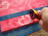 Put painter's tape down to mark where to stop cutting with your rotary. Smart! This site teaches other methods to the no sew fleece blankets.