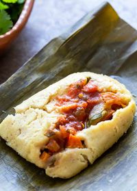 Banana leaf tamales recipe. Tamale corn masa, stuffed with cheese, calabasitas squash, carrots, tomatoes, garlic, and chili sauce, wrapped in banana leaves and steamed.