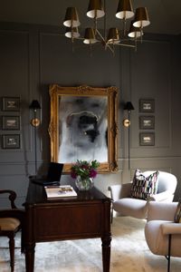 "Opting for a medium-to-dark gray paint infuses a space with timeless sophistication. Sherwin Williams Anonymous Gray exemplifies versatility, creating a refined and elegant ambiance. By color-drenching this home office space with a uniform shade across the ceiling, walls, and trim, a cohesive and subtly moody atmosphere is achieved that enhances the room's depth and sophistication."