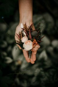 Wild wonderful buttonhole of regular size (for grooms) in burned/soft orange, ivory, peach and eucalyptus-green tones, made of nice preserved and dried flowers and grasses, nice textile/artificial flowers, preserved plants of various kinds of preserved eucalyptus. What are preserved plants and