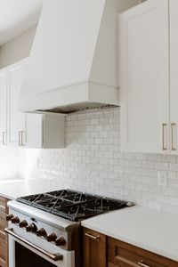 Two toned kitchen custom hood vent and shelving. white subway tile backsplash. #kitchens #kitchendesign #kitchen #interiordesign #design #kitchendecor #kitcheninspo #kitchenrenovation #kitchensofinstagram #kitchenremodel #interior #kitchenideas #kitcheninspiration #customhoodvent #twotonedkitchen