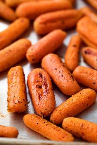 These simple roasted carrots are made easily on a sheet pan, with a simple roasting method that brings out the natural sweetness of the baby carrots.  They're the perfect side dish!  #roasted #carrots #sidedish #holidayrecipe #carrotrecipe #sheetpan #healthy #side #thanksgiving