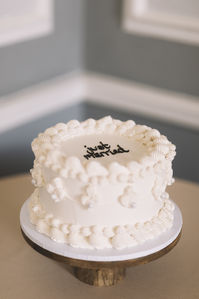 'Just Married' wedding cake written in black icing on all white retro wedding cake | wedding cake design | vintage wedding cake | kitsch wedding cake | classic and chic wedding cake for city wedding | Lauren Elliott Photography