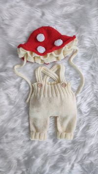 Introducing our charming Mushroom Hat and Romper Set! This adorable ensemble features a red mushroom-inspired newborn hat with white spots, perfectly paired with cream-colored baby pants. Crafted with super soft and cozy yarn, including a blend of bamboo and organic materials, this set ensures maximum comfort for your little one. It's the perfect choice for capturing precious moments during a knit photo prop session or as a gender-neutral hat for everyday wear. The toadstool bucket hat adds a wh