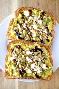 Avocado Toast - Try this over-the-top Avocado toast, made with chili paste, lime juice, crumbled feta cheese, seeds and balsamic glaze, for a filling and flavor packed breakfast that'll keep you going all day. #avocado #toast #feta #balsamic #breakfast #bread #pipercooks