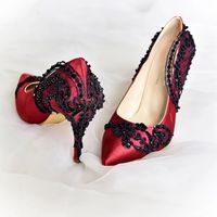 Step in exquisite style wearing these burgundy and black lace embellished stilettos on your wedding day. Crafted from bordeaux satin fabric and hand embroidered with beaded floral black lace, these bridal shoes surely will turn heads on your feet! Pointy toes and stiletto heels create an elegant look, while the sparkly sequins and shiny black beads compliment your moody wedding theme beautifully... Order custom heel heights and custom-fit sizes now. #weddingshoes #burrgundywedding #bridalshoes