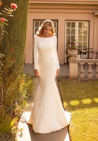 Crepe long sleeve fit and flare bridal gown with cowl back, illusion panel with visible boning. Sampled in bridal size 16, in ivory. Can be ordered in sizes 2-28, ivory only. 