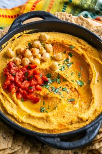 Red pepper hummus is classic hummus with roasted red peppers added to it. It's vegan, gluten free, and enjoyed by people of all ages at any event! #hummus #redpepperhummus