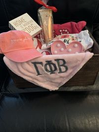 There is a full sized Gamma Phi Beta flag, a sweater, t-shirt, lotion, hat, personal gift, light, and blanket. The basket has chalkboards on the sides