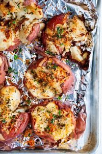 Herbed Garlic Parmesan Smashed Potatoes - Snazz up those regular roasted or boiled potatoes with this delicious, flavorful smashed potato recipe! Topped with plenty of fresh herbs, parmesan and garlic for extra flavor. From aberdeenskitchen.com #potatoes #smashed #herbed #parmesan #sidedish #recipe #easy #glutenfree #vegetarian #stpatricksday