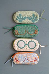 These charming handmade sunglasses cases are more than just protection; they're mini works of art featuring prints from the Suzy Quilts Evolve Collection!  Hand-stitched details elevate them to pure inspiration! Dive into our Evolve Lookbook for more creative sparks! #ArtGalleryFabrics #AGFEvolve #QuiltingCotton FabricCrafts #DIYProjects #Sewing #DIYHandmade #SmallSewingProjects #TextileProjects #HandSewing #Embroidery #CuteDIY #Quilting #SewingProjects #SpringCrafts #SummerCrafts #DIYPouches