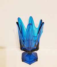 "Hi, This is a vintage, 1960's or 1970's, 9\", Viking Glass, blue \"Bluenique\", blown glass footed vase.  This piece is in very good, used condition. It is not chipped or broken. It does have an area where the sides are folded in on themselves. This happened while it was being made, while the glass was still hot. It just makes it a little more interesting. You can see the areas I am speaking of in photos # 5 and # 6. Please make sure to look at all the photos, they are part of the description.