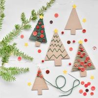 Christmas trees cut out from cardboard and adorned with cotton and buttons.