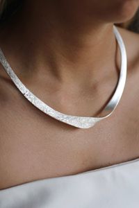 Product Highlights A statement collar necklace with contrasting textures. Style with the matching Praise Earrings Silver, Praise Bangle Silver and Praise Ring Silver. Handcrafted from Recycled & Traceable Materials Brass base plated with Sterling Silver. Finished with an anti-tarnish, water resistant coating. All of our jewellery is hypoallergenic and comes with a 12 month warranty. Presented in a recycled fabric pouch. Dimensions Diameter: 14cm As well as the adjustable clasp this necklace can