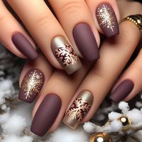 Elegant winter nail art with a matte finish in deep burgundy, adorned with gold snowflake accents