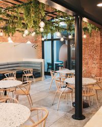 Biophilic ceiling plants for a restaurant interior by Arti Green Ltd. The green and floral ceilig was created with a mesh structure / canopy with faux planting for zero maintenance.