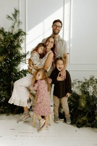 Festive all white studio family christmas card photoshoot with live greenery install