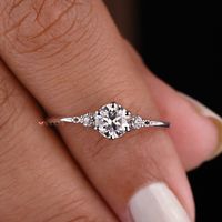 0.55 CT Round Cut Colorless Moissanite Ring, Unique Three Stone Engagement Ring, Minimalist Ring For Women, 6 Prong Setting, Promise Ring, Dainty Ring, Proposal Ring, Handmade Ring, 14K White Gold Anniversary Ring, Moissanite Jewelry, Moissanite Diamond Ring, Avideri 𝐈𝐭𝐞𝐦 𝐒𝐩𝐞𝐜𝐢𝐟𝐢𝐜𝐚𝐭𝐢𝐨𝐧: Center Stone Shape: Round Brilliant Cut ◼Carat Weight: 0.50 CT ◼Dimension: 5.00 MM ◼Color: Colorless ◼Clarity: VVS ◼Cut Grade: Excellent Side Stone Shape: Round Brilliant Cut ◼Carat Weight: 0.05 CTW ◼Dimension: 1.80 MM ◼Color: Colorless ◼Clarity: VVS ◼Cut Grade: Excellent Bandwidth: 1.30 MM | Thickness: 1.50 MM 𝐌𝐞𝐭𝐚𝐥 𝐝𝐞𝐭𝐚𝐢𝐥𝐬: 1. We can make this item in 10KT, 14KT, and 18KT gold. 2. You can choose any metal like white gold, yellow gold, or rose gold. ◼Please send me a message if