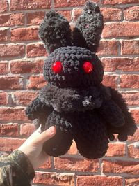 Fill your inner [ V O I D ] with this precious handmade Mothman plushie! Your Mothman buddy can be made in various color combinations, depending on availablity. Message me for requests and we can talk about colors. Made to order, work time is 3-5 business days before shipping. Made with regular and fluffy polyester yarns, polyfil, safety eyes, and wooden skewers. **Not recommended for small children.** Mothman pattern and red safety eyes by Mom's Stitchetti.