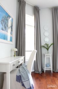 Adding an Office Space to a Guest Room | House Full of Summer - coastal bedroom decor, beachy guest room, desk in a bedroom, multipurpose spaces, home office ideas, desk, console table, white slipcovered chair, beach art, extra tall curtains, long curtains, Florida home, beach house style, blue gray white interior