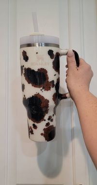 Handmade Stanley and other brands, Cow Print / Cow Hide tumbler,    will come with a lid and straw. There are several sizes and brands to choose from, Tumbler is decorated by me with cow print/Cow Hide, and then the epoxy method is used to seal the tumbler. No 2 tumblers are just a like as they are handmade, each Cow spot may differ than what you see in the photo but will be very similar. The difference may be the size of cow spots or  cow spot placement. You can pick the size of the cup you want and also if you prefer black and brown spots or just black. The Turn Around Time  time is  3 weeks as these are handmade and made to order. Check out all of my other items as well. 100% authentic Syanley