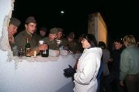 West Germans bring food and drink to East German border guards after the fall of the Berlin Wall, on 10 November 1989.