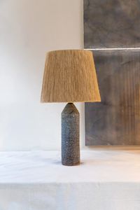 This handmade Terre Black Ceramic Table Lamp by Grès Ceramics lets craftsmanship really shine through. Each ceramic foot has a unique and distinct patterns that can only be achieved through artisanal creation. The quirky hand knotted jute screen adds a bohemian feel to any interior.